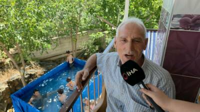 Hatay'da hava sıcaklığının 35 dereceyi bulmasıyla, torunlarını serinletip eğlendirmek isteyen